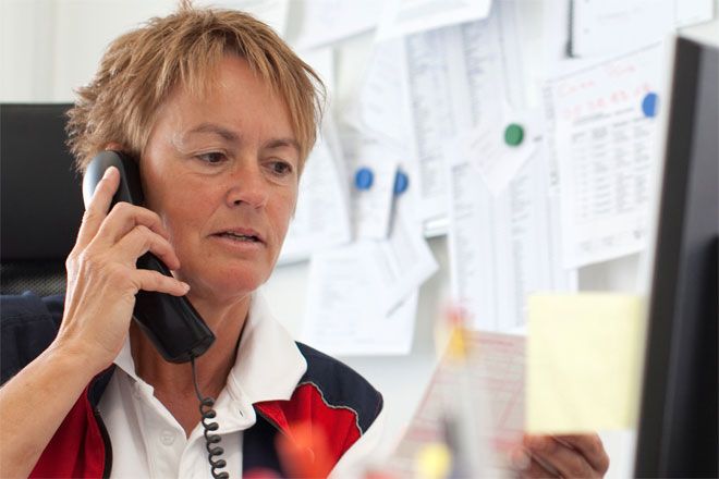 Foto: Eine Pflegedienstleitung des DRK disponiert die Einsätze ihrer Mitarbeiter am Telefon.