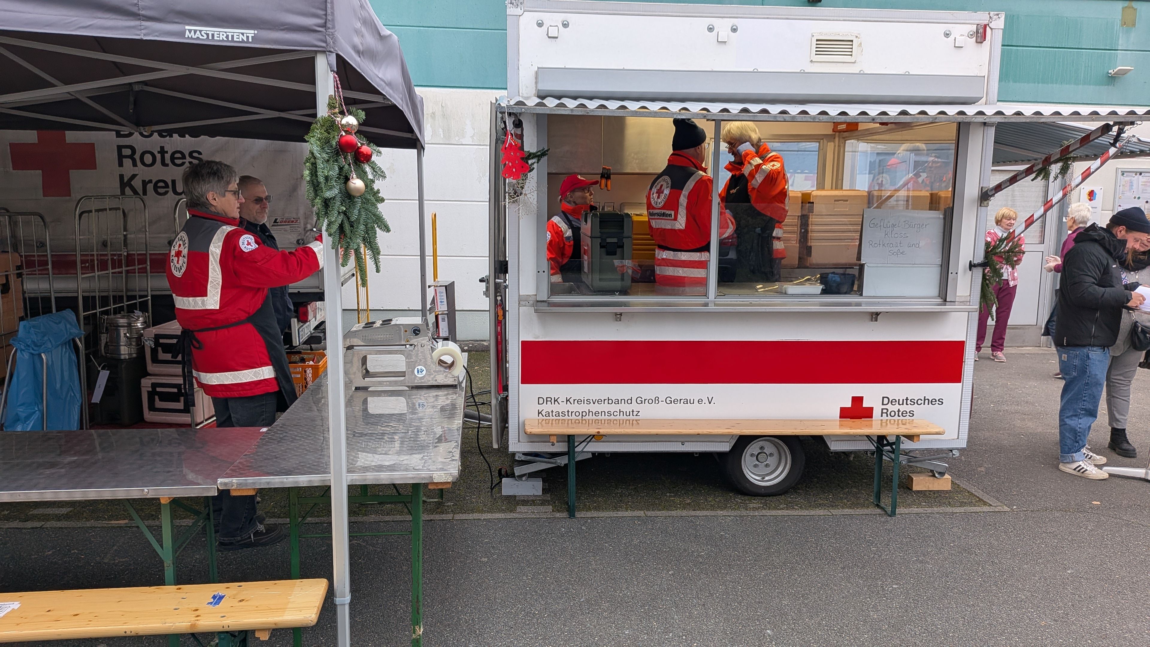 Ehrenamtliche Helfer*innen verteilen ein warmes Essen an Bedürftige.