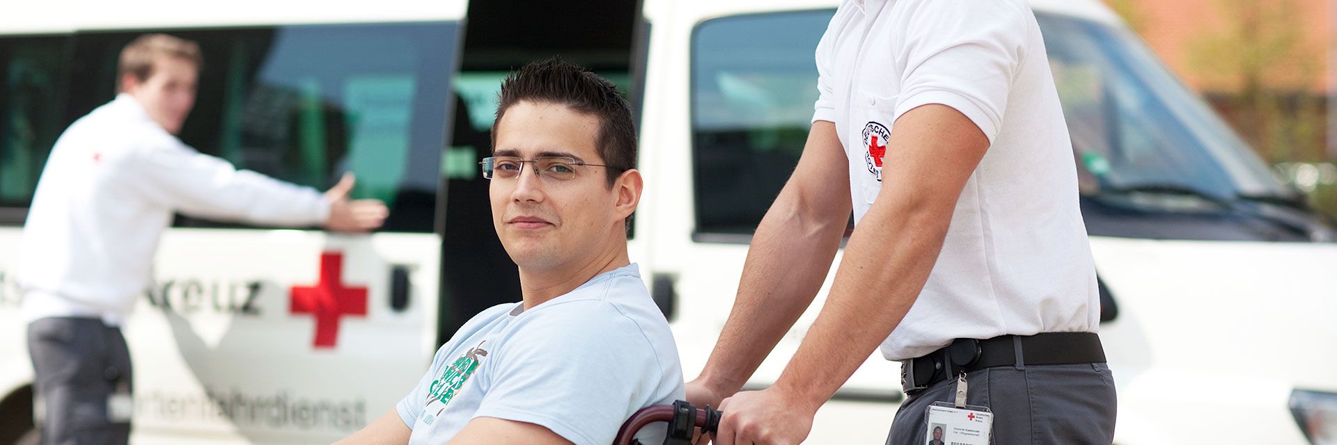 Foto: Zwei Mitarbeiter des DRK-Sanitätsdienstes tauschen sich am Spielfeldrand fachlich miteinander aus. Der Sanitätsrucksack liegt geöffnet zwischen den beiden.