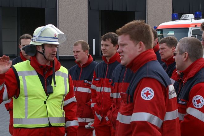 Foto: Eine Gruppe von Helfern erhält bei einer Praxisübung detaillierte Instruktionen.
